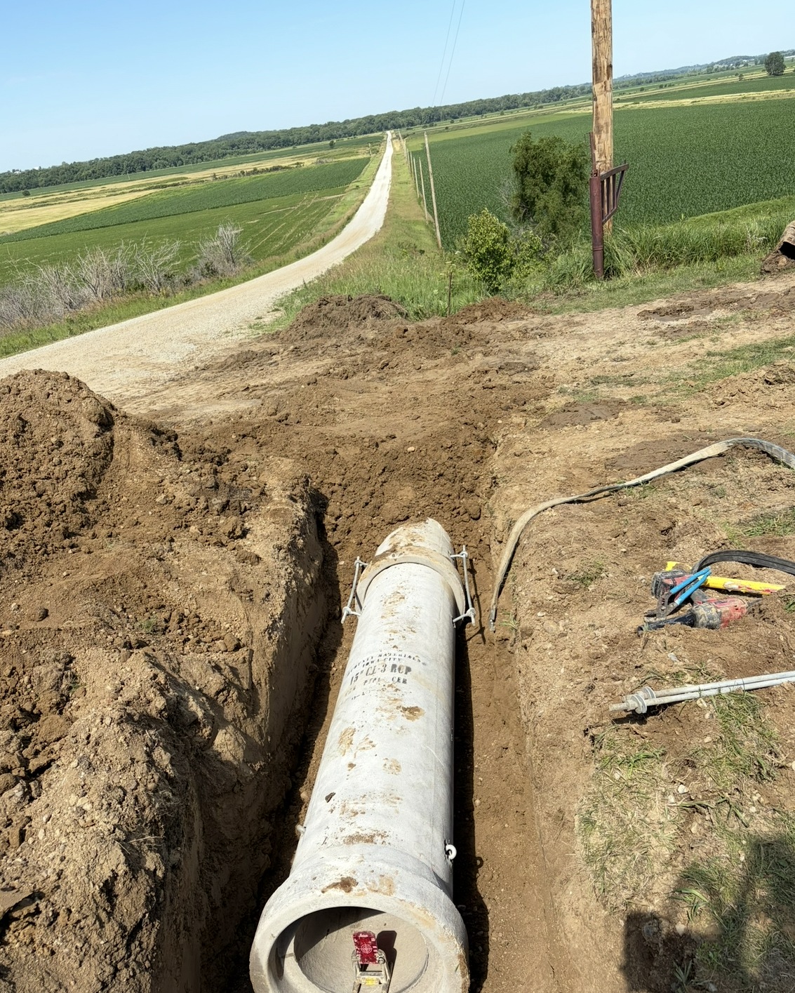Private water line trench with large pipe installed in a rural Iowa setting